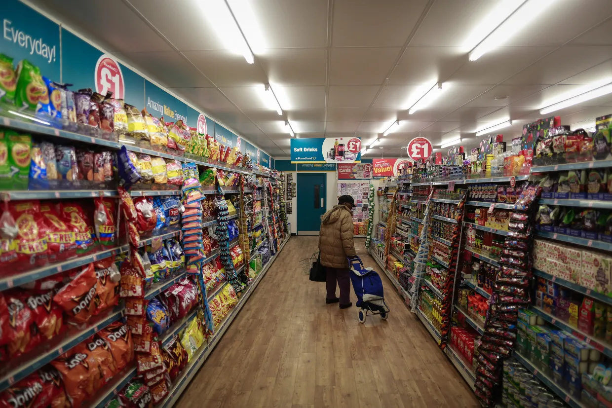 A customer pulls a shopping cart&nbsp;along an aisle inside a Poundland Store in London.&nbsp;