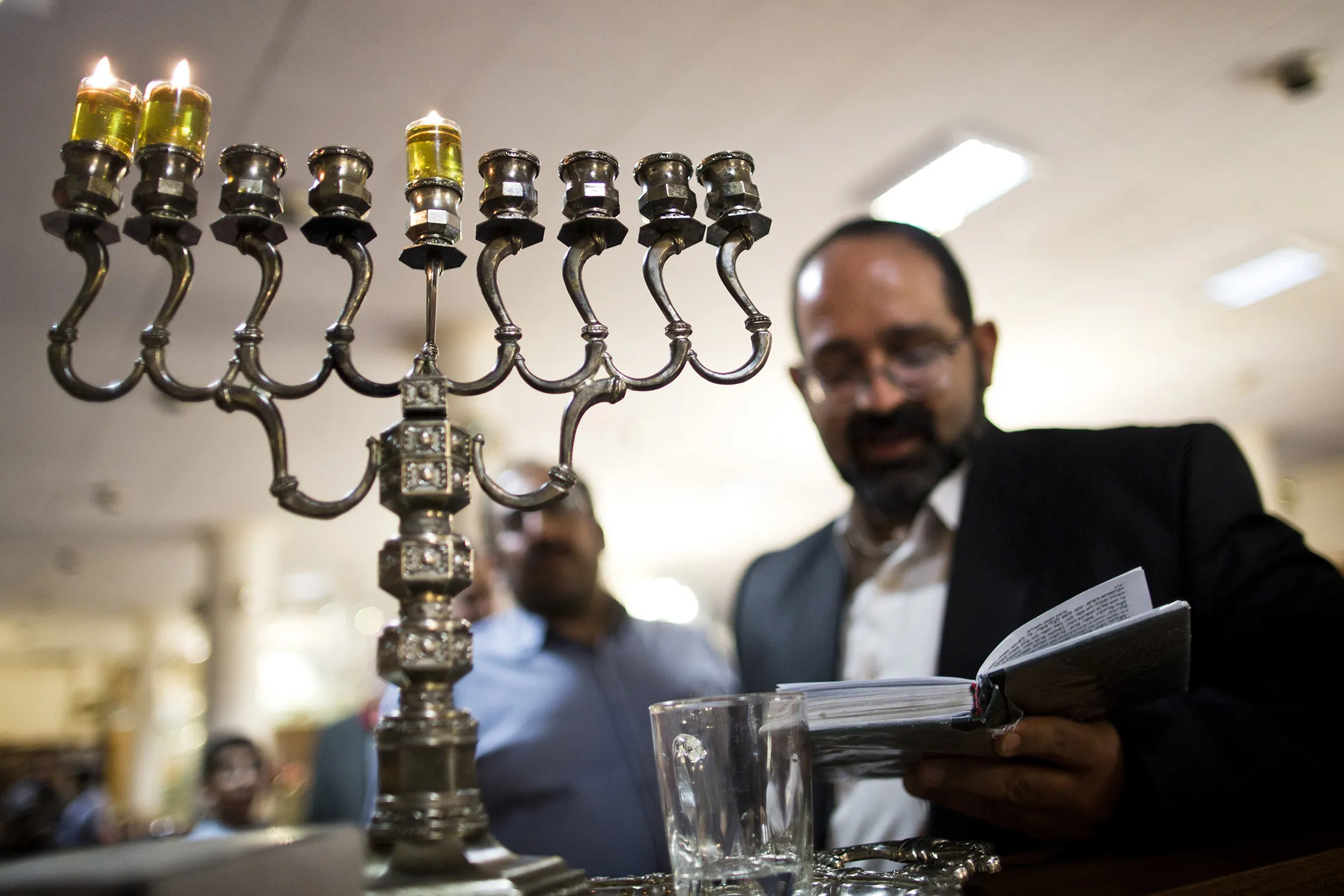 Iranian Jewish Rabbi reads prayers after lighting candles to mark Hanukkah, the festival of lights, at Abrishami synagogue in downtown Tehran.
