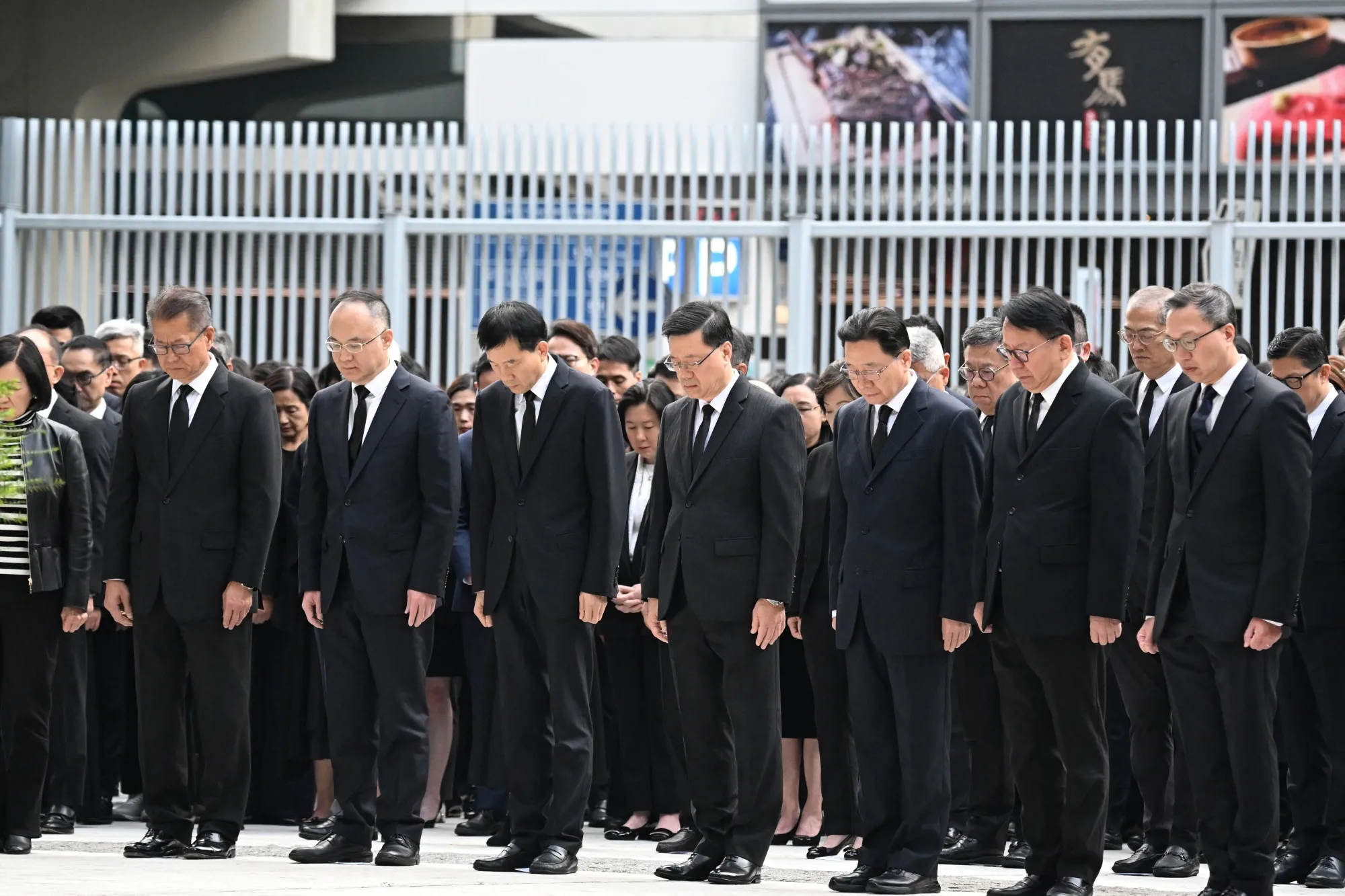John Lee, center, and other government officials observe three minutes of silence to mourn victims of the Wang Fuk Court residential estate fire at the Central government offices in Hong Kong on Nov. 29.
