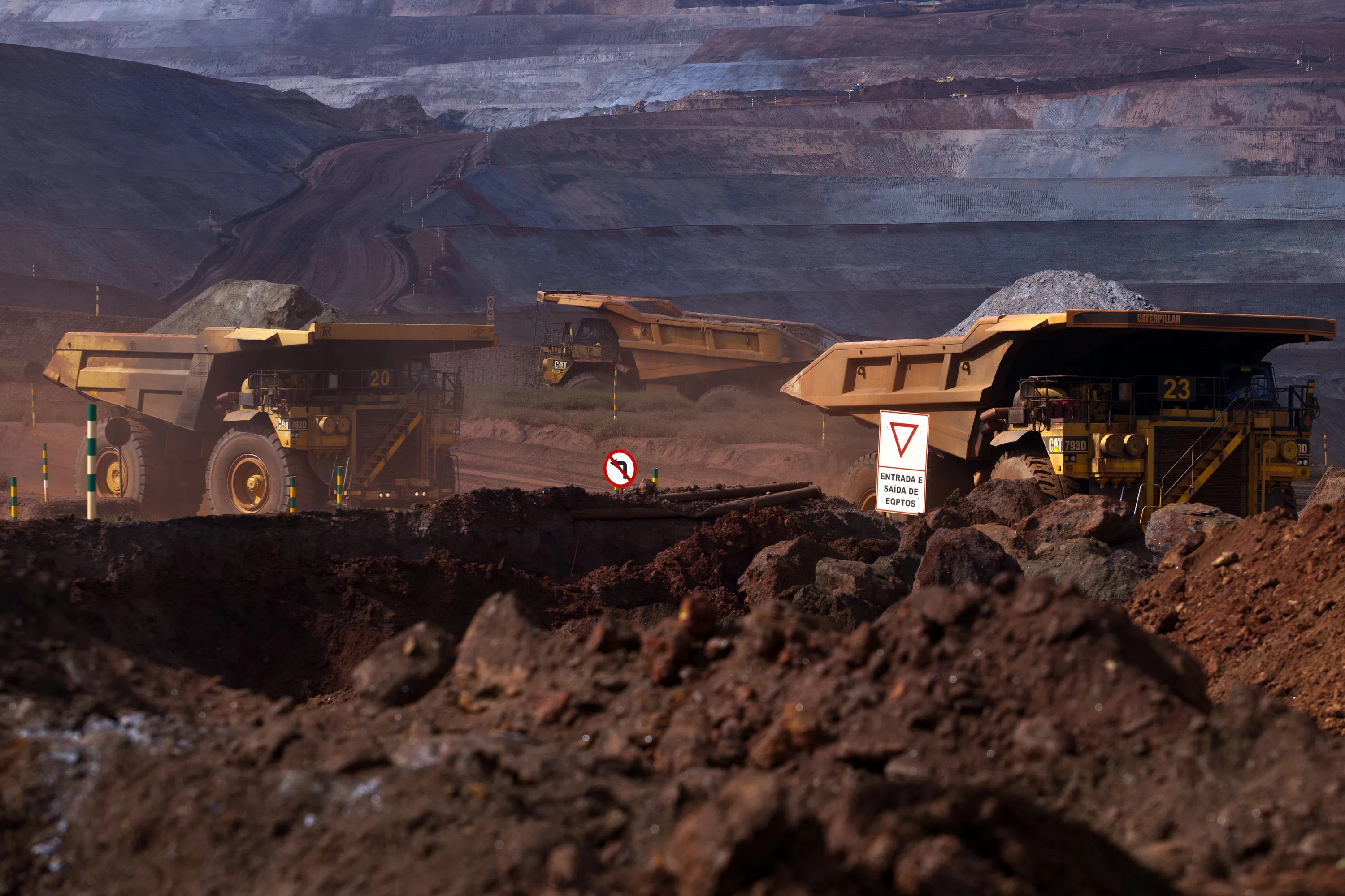 Dump trucks transport carry mined iron ore at Vale SA's Brucutu mine in Barao de Cocais, Brazil.