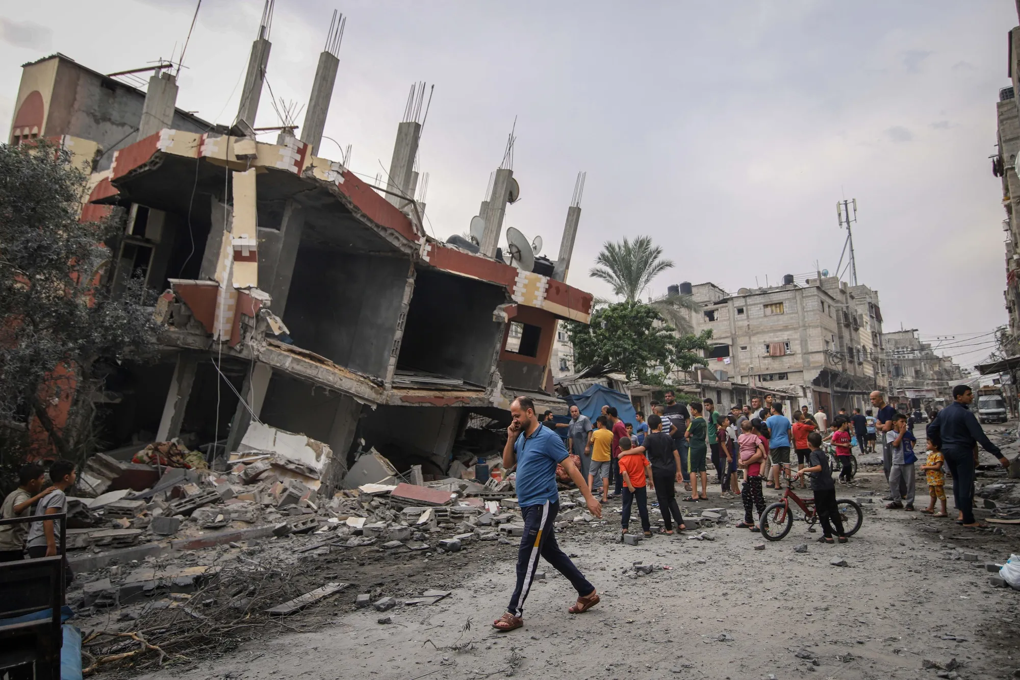Palestinian residents survey the damage to a destroyed building following Israeli airstrikes overnight in Khan Younis, Gaza, on Monday. The death toll from the conflict between Israel and Hamas topped 1,500 as fighting continued for a third day following a surprise attack by the militant group.