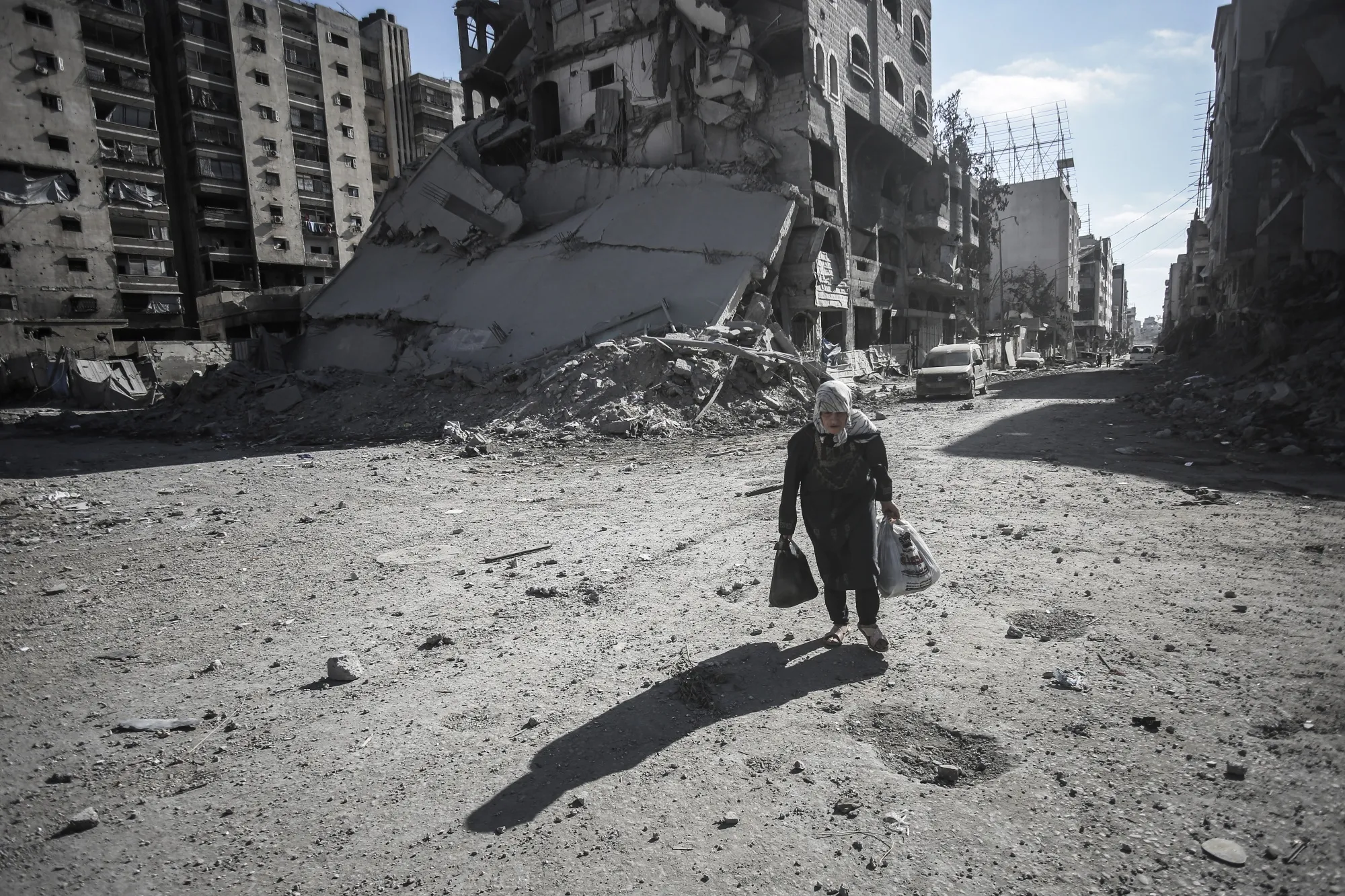 A Palestinian woman walks over blast debris in Gaza City in September.