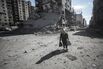 A Palestinian woman walks over blast debris in Gaza City in September.
