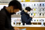 Customers wearing protective masks look at smartphones at the Samsung Electronics Co. D'light flagship store in Seoul, South Korea.
