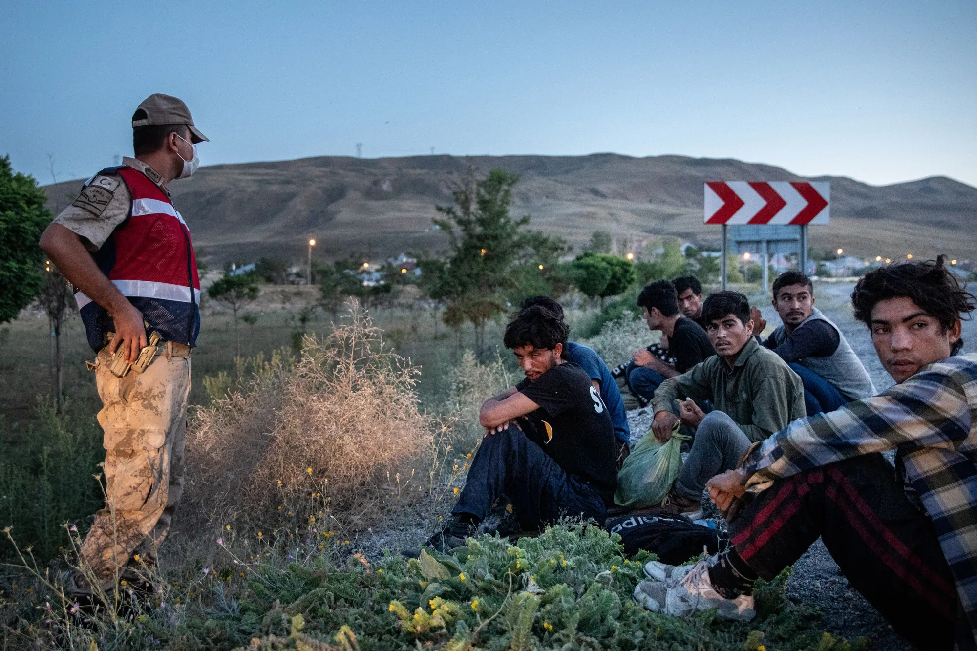 An officer watches over migrants&nbsp;found in a smuggler’s car in Van, Turkey.