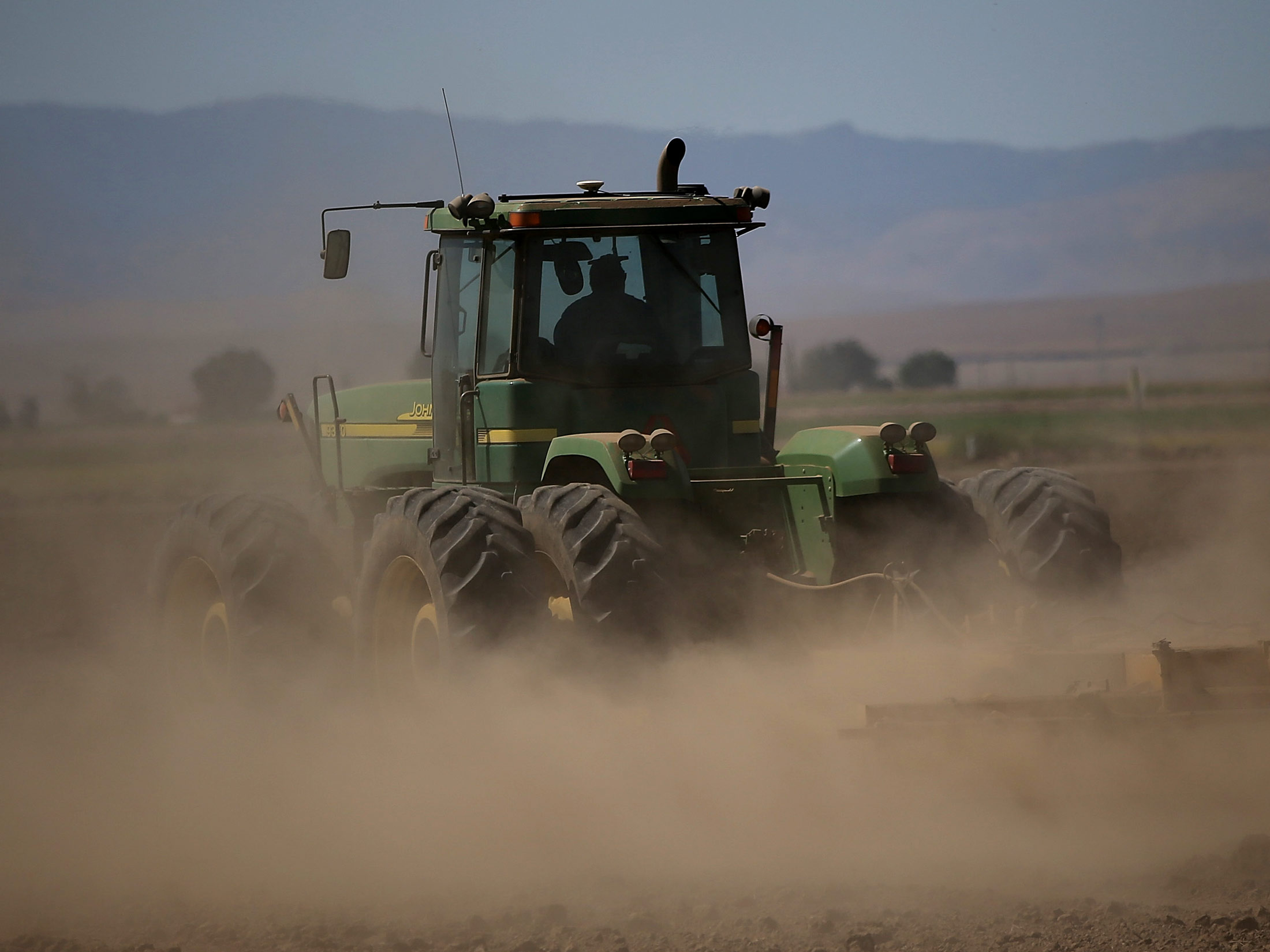A tractor kicks up dust in Los Banos, California.
