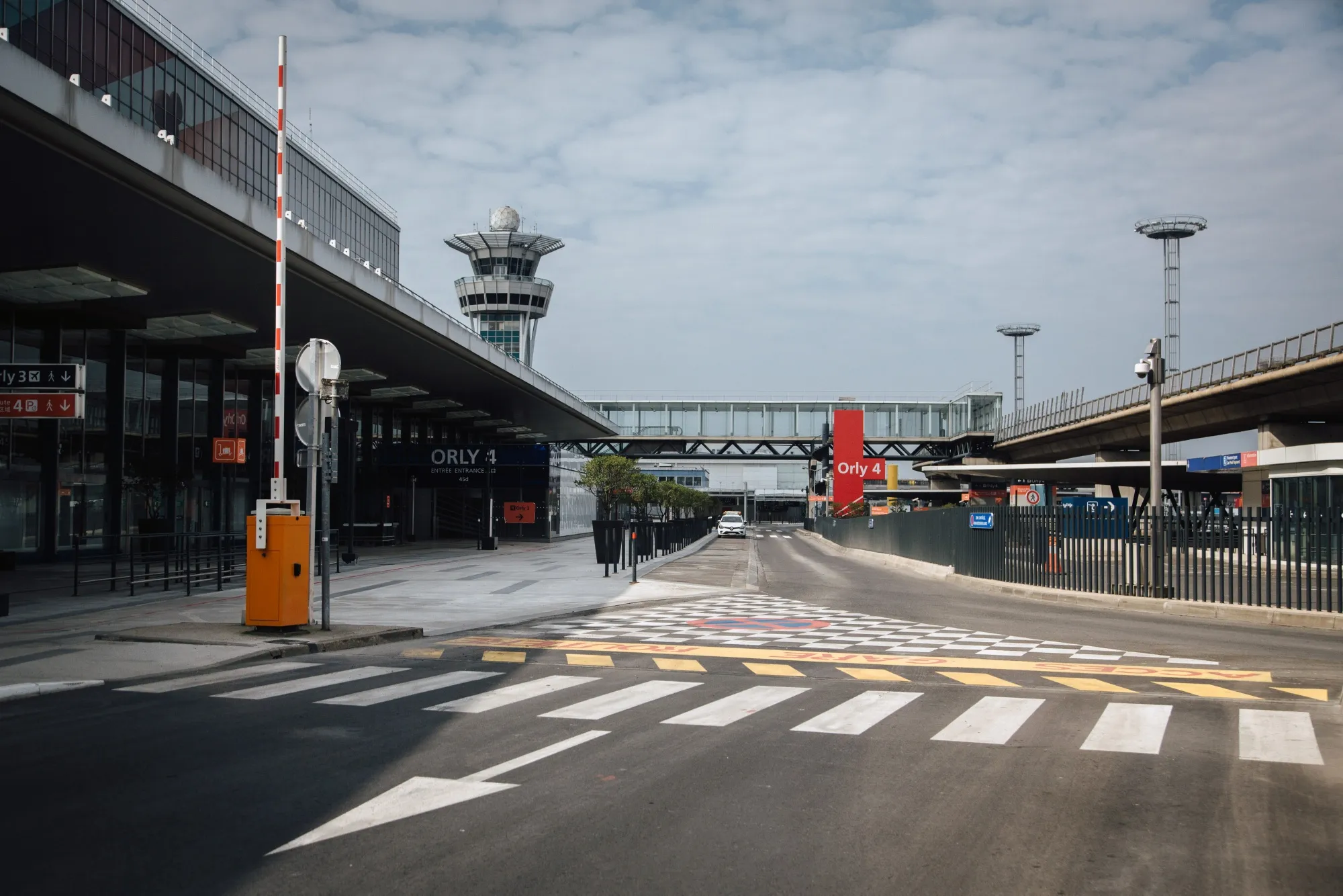 The flight control tower stands beyond an empty access road at the non-operational Orly airport, near Paris, France, on April 11.
