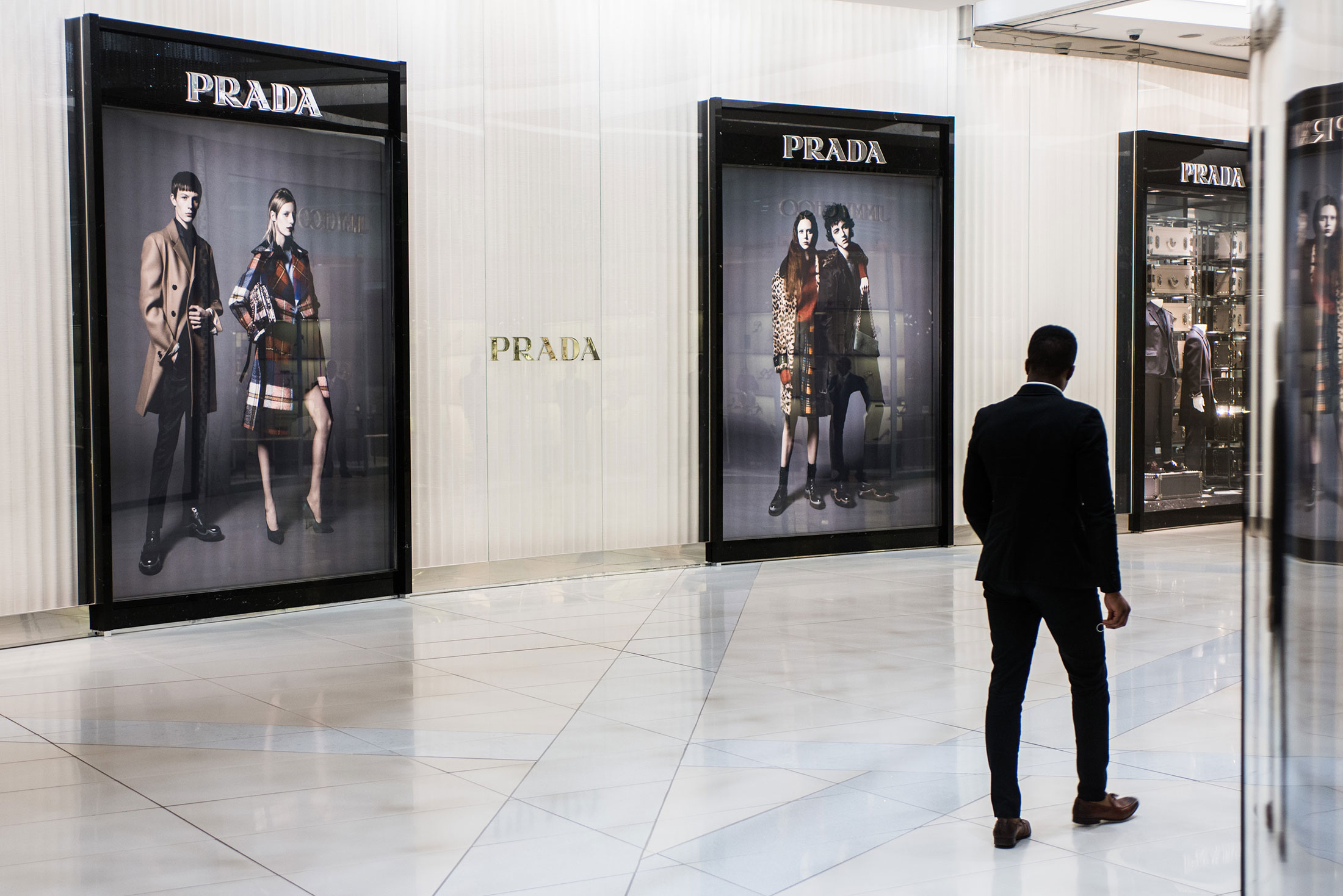 A woman walks pass a Louis Vuitton advertisement in a shopping mall News  Photo - Getty Images