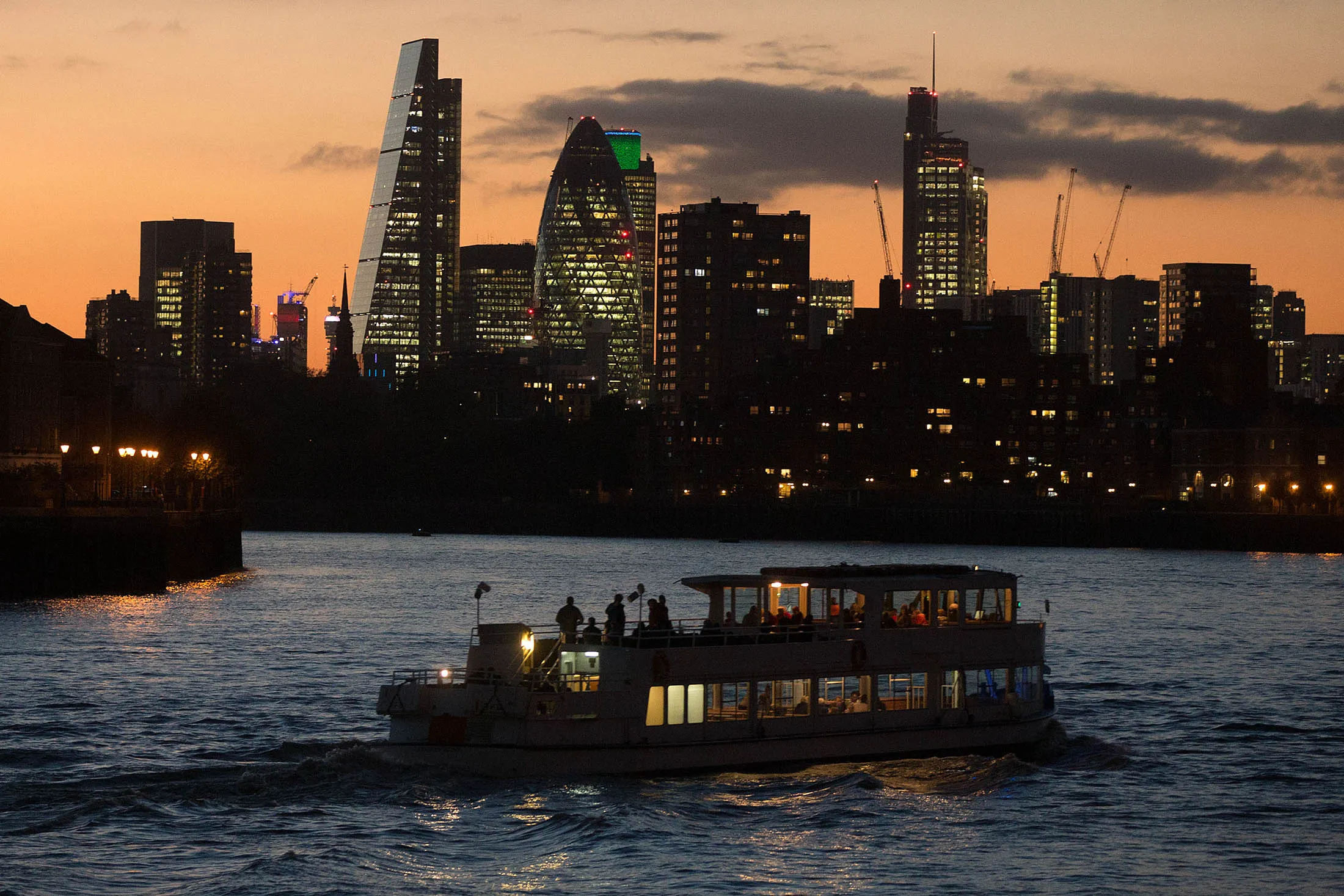 A tourist boat travels along the River Thames towards the City of London skyline in London, U.K., on Wednesday, Oct. 28, 2015. In its monthly consumer confidence index, GfK said a measure of Britons' outlook for the economy over the next 12 months dropped to minus 4 in October, the lowest reading this year.
