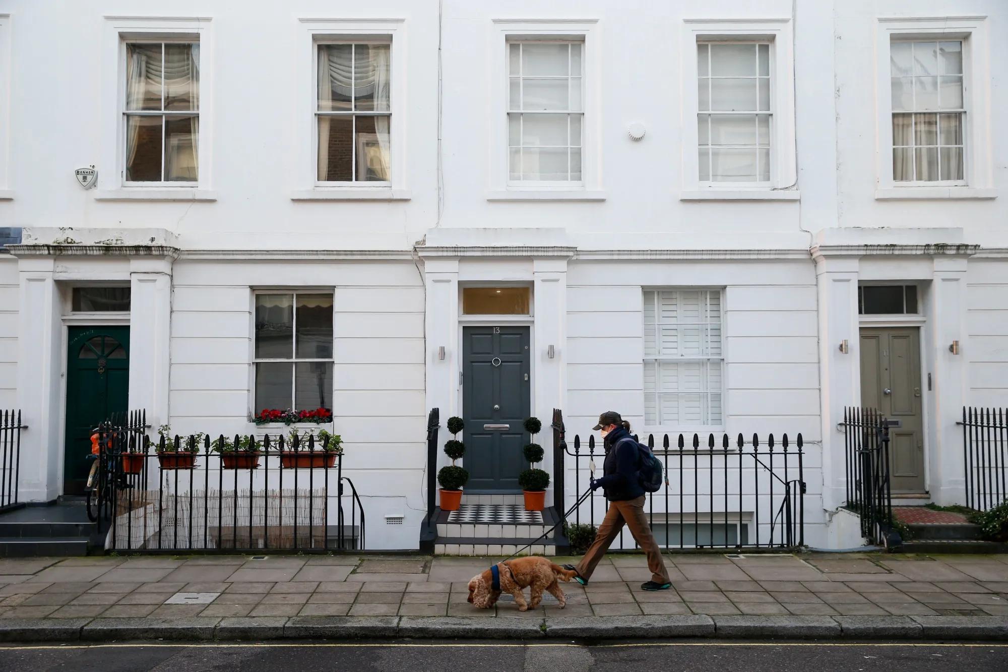 A pedestrian walks past residential properties in London.