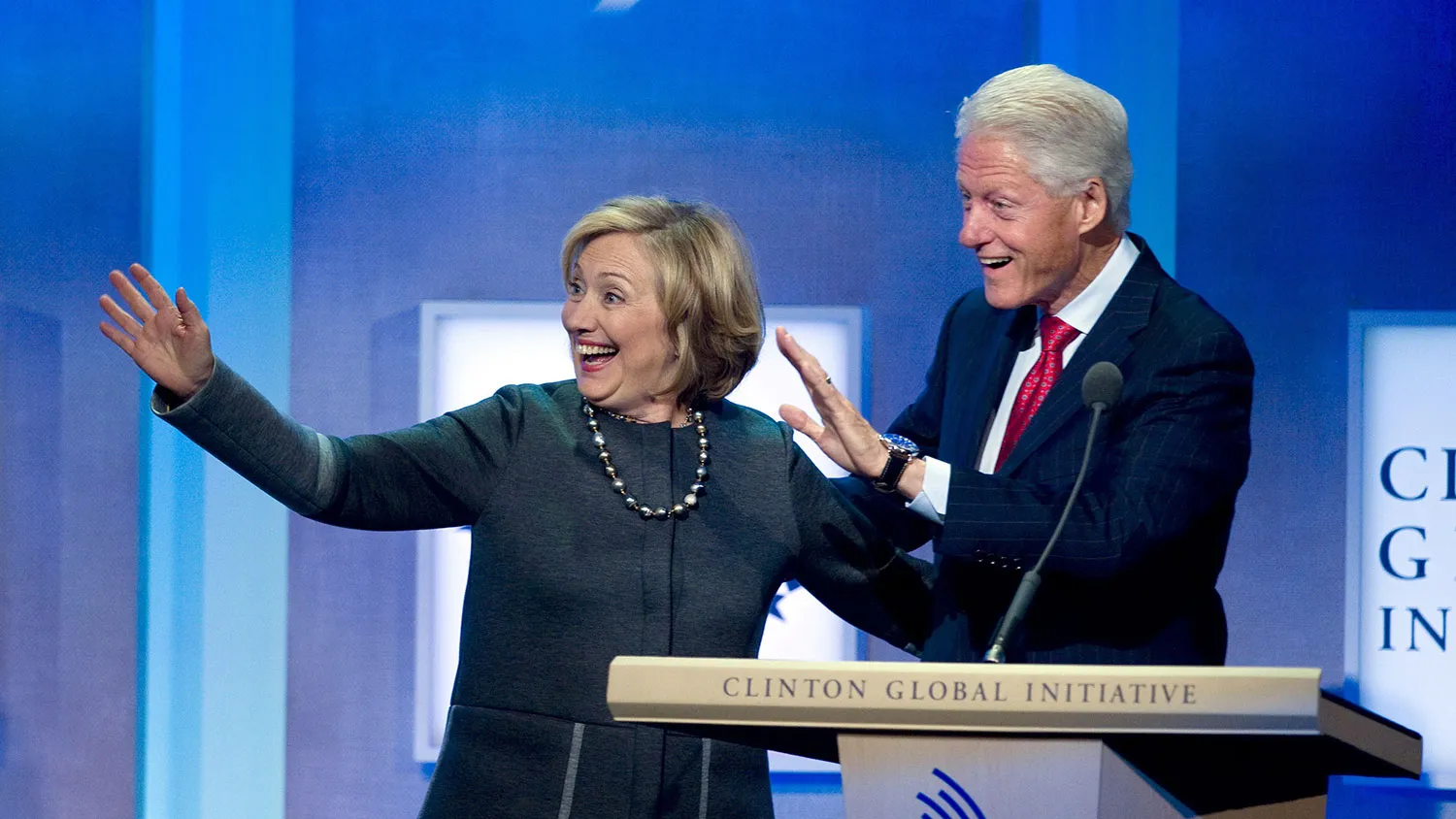 Former US President Bill Clinton waves with former US Secretary of State Hillary Clinton during the 2014 Clinton Global Initiative annual meeting in New York September 22, 2014.
