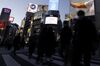 Pedestrians cross an intersection at dusk in the Shibuya district of Tokyo, Japan, on Wednesday, Feb. 17, 2021. Bank of Japan Governor Haruhiko Kuroda says it will be hard for the bank to attain its price target even in 2023, hinting at the need to keep monetary easing rolling long after his current term ends.