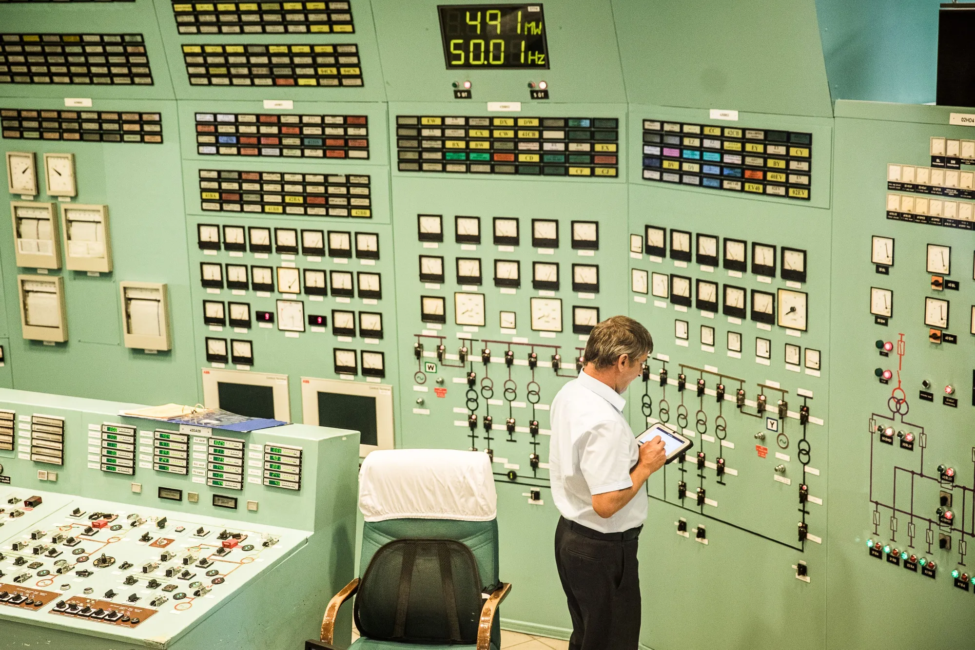 An employee holds a tablet device in the control room at the Paks nuclear power plant in Hungary.&nbsp;