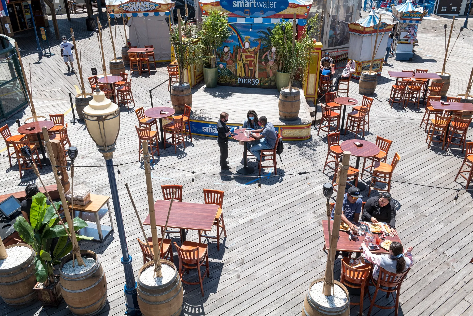 A waiter wearing protective gloves and a mask takes an order from customers at a restaurant on Pier 39 in San Francisco, California, U.S.,&nbsp;June 22.