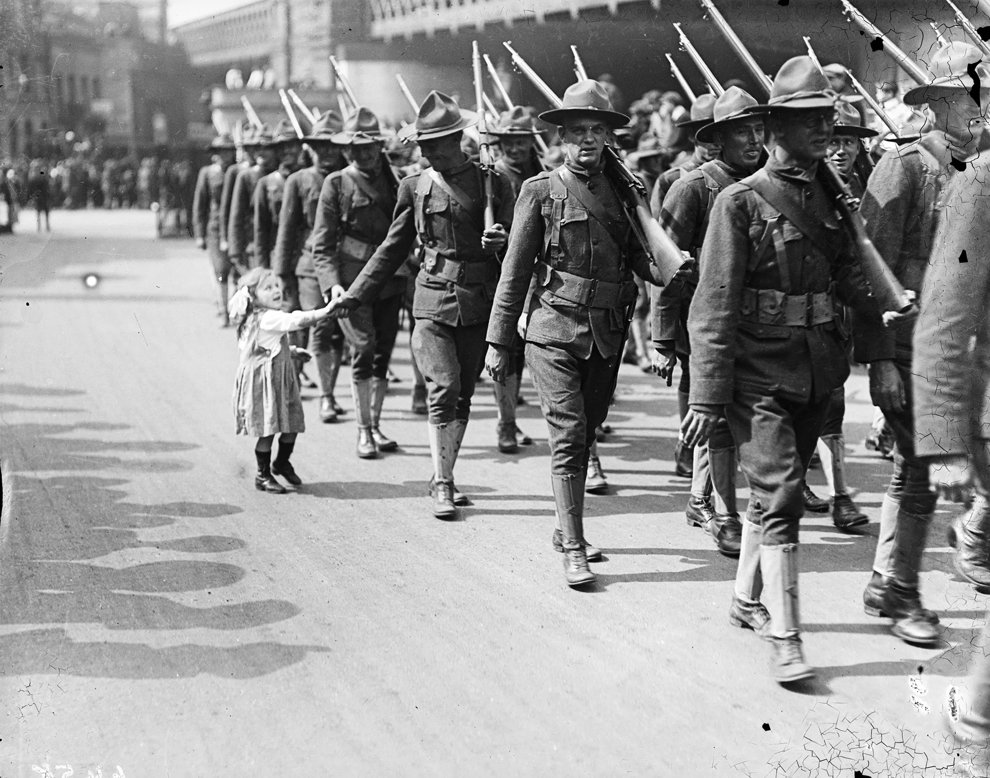 A little girl has her hand shaken by an American&nbsp;soldier on the streets of London on&nbsp;Aug. 15, 1917.&nbsp;