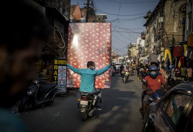 A rider on a motorcycle carries a mattress at a market in Lucknow, India, on Wednesday, Oct. 13, 2021. The Reserve Bank of India expects the months-long festival season to bolster urban demand in the second half of the financial year to March 2022, while rural demand will likely be buoyed by a robust monsoon and record food grain production.