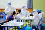 Health workers collect samples at a Covid-19 testing center in Selangor, Malaysia.