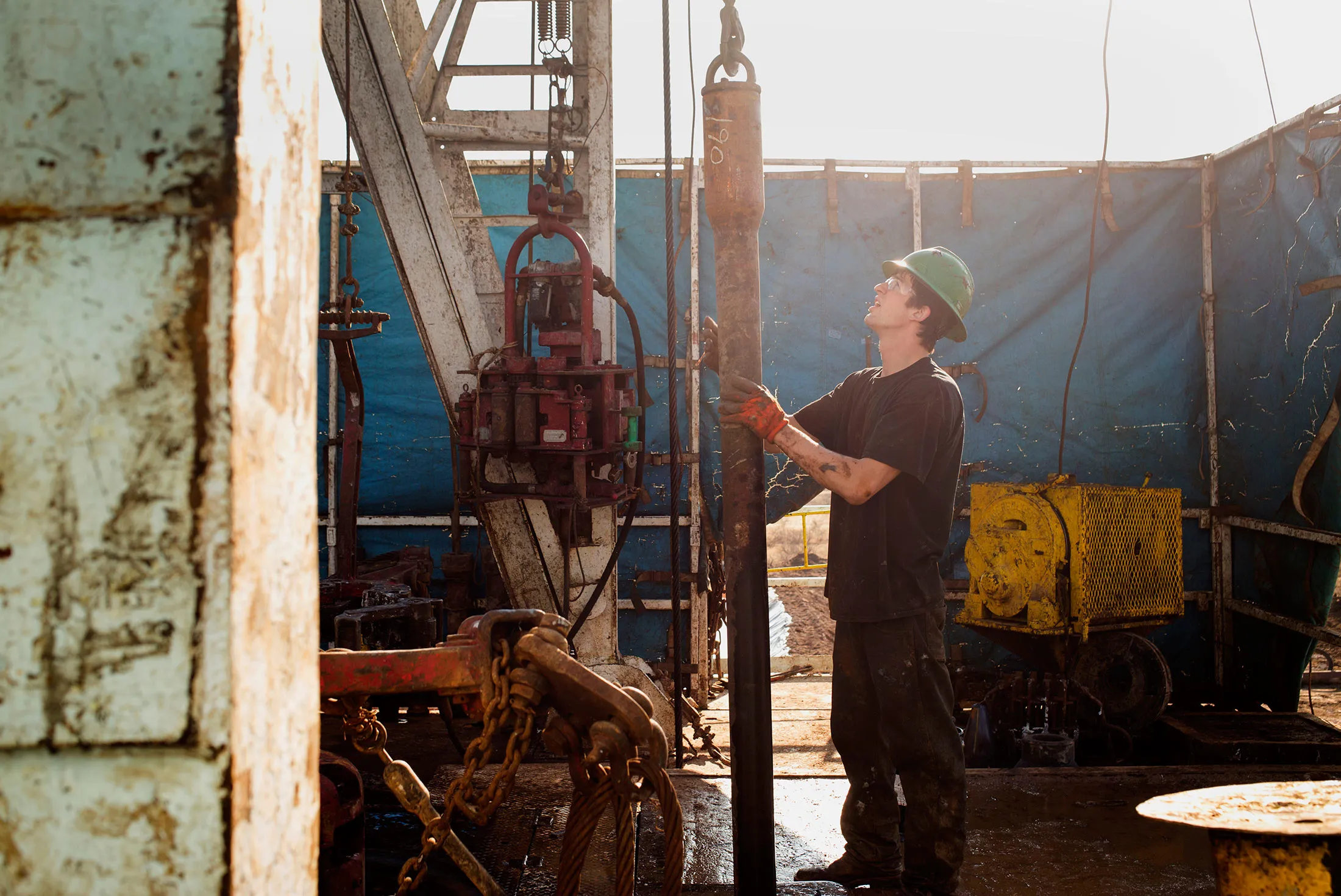 A worker checks the drilling rig before attaching it to the turntable on Endeavor Energy Resources LP's Big Dog Drilling Rig 22 in the Permian basin outside of Midland, Texas, U.S., on Friday, Dec. 12, 2014.
