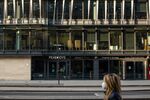 A pedestrian wearing a protective face mask passes closed restaurants and office floors, devoid of staff, in London, U.K.