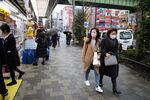 Visitors wearing face masks walk along a sidewalk in Tokyo's Akihabara area, Japan, on Tuesday, Jan. 28, 2020.