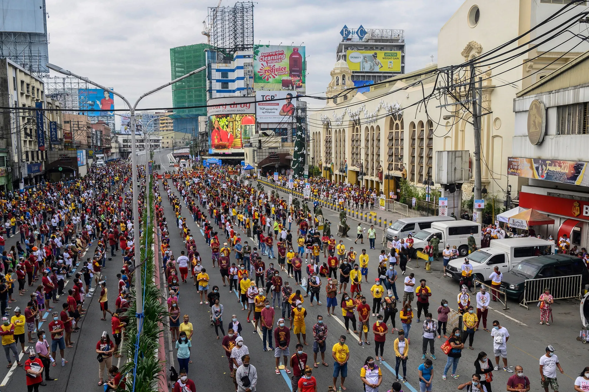 Devotees observe social distancing to attend mass on a road near Quiapo church in Manila on Jan. 9.