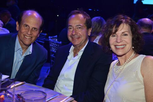 Mike and Lori Milken with John Paulson