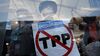 A supporter of Senator Bernie Sanders holds a sign against the Trans-Pacific Partnership (TPP) while demonstrating inside the media tent during the Democratic National Convention in Philadelphia on July 26, 2016.
