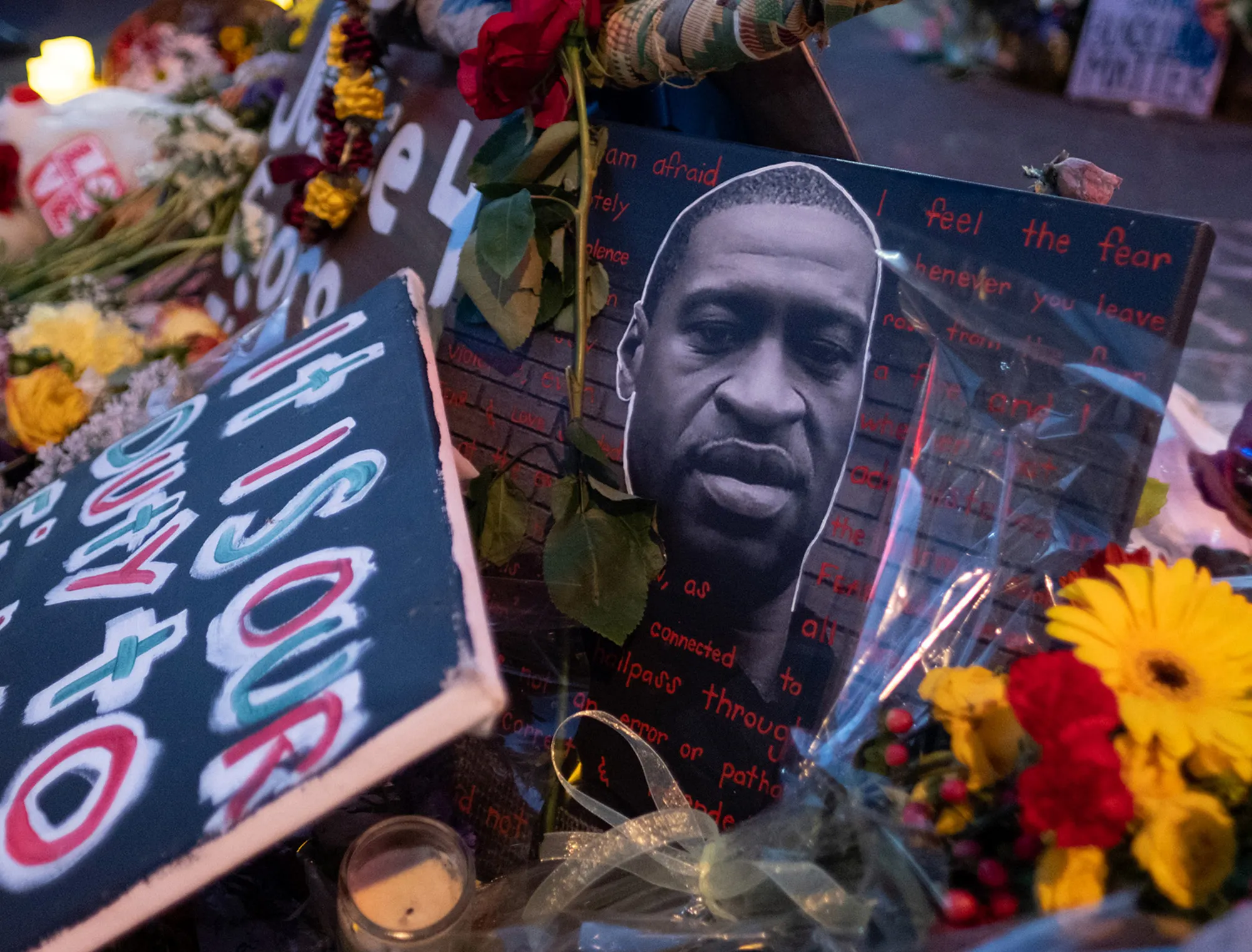 Flowers and signs line the sidewalk during a vigil for George Floyd in Minneapolis, Minnesota, on May 25, 2021. A report commissioned after his death found rampant discrimination by city police.&nbsp;