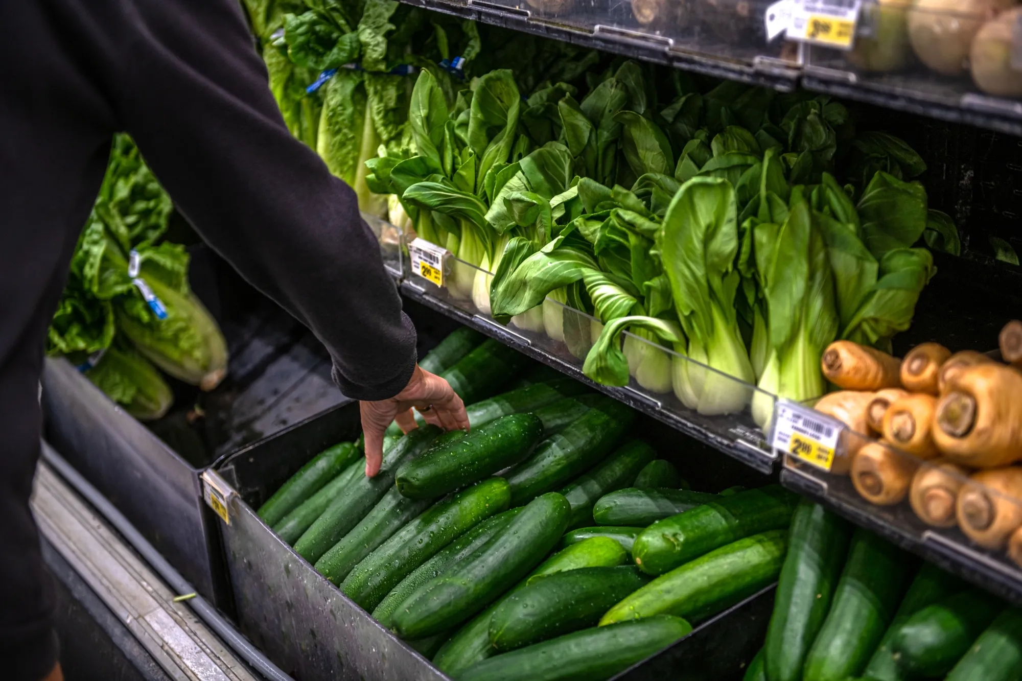 A customer picks out vegetables at a grocery store in Scottsdale, Arizona.