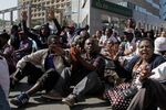Demonstrators sit and sing protest songs after police cordoned off the street in Harare, on Aug. 16.