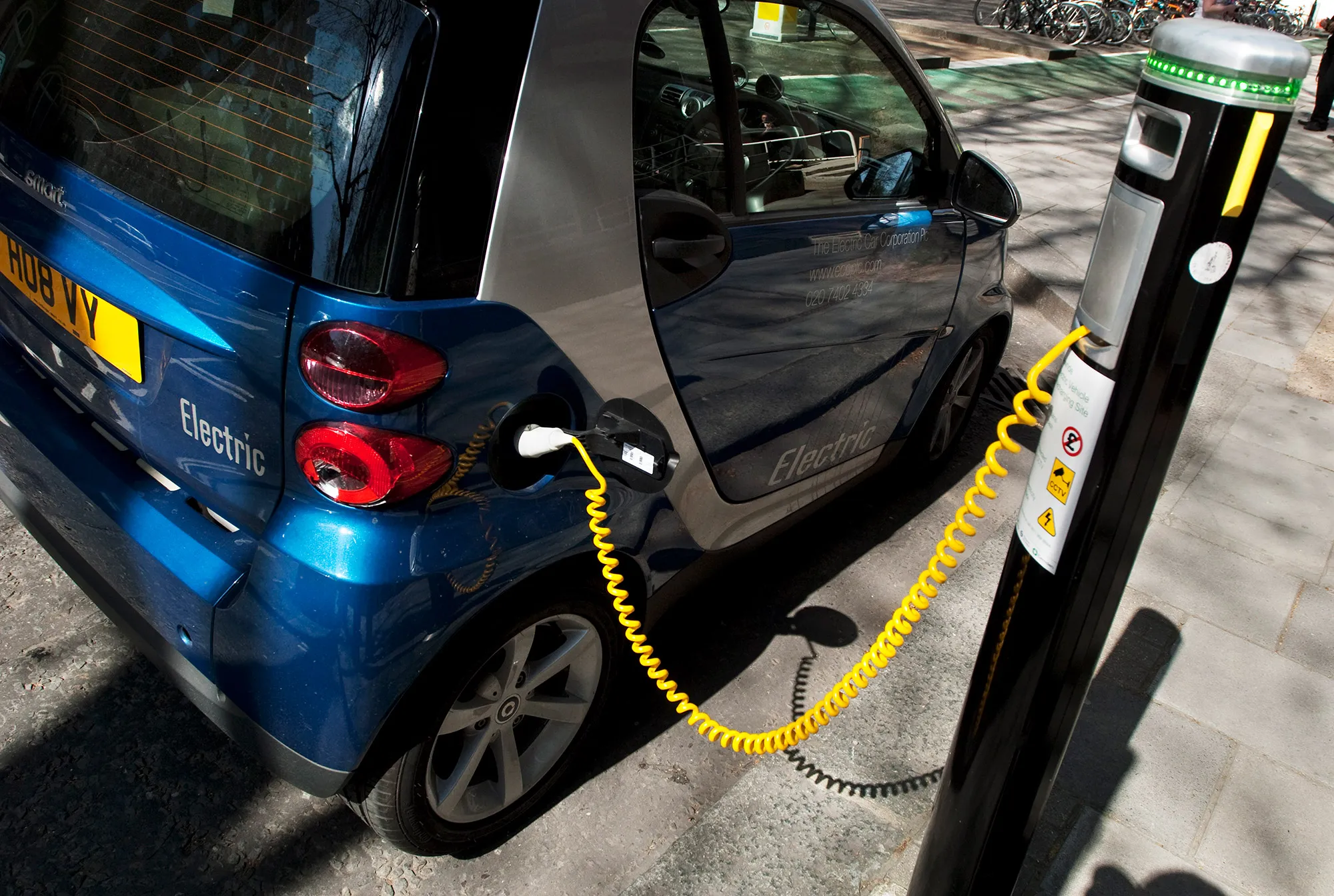 Electric car receiving a charge from a special allocated city parking bay, Central London.