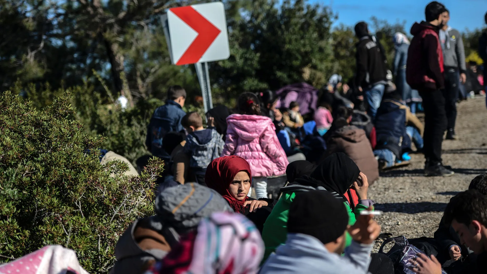 A woman sits on the side of a road after being detained by Turkish soldiers with other Syrians trying to reach the Greek island of Lesbos from Dikili, western Turkey, on March 5, 2016.
