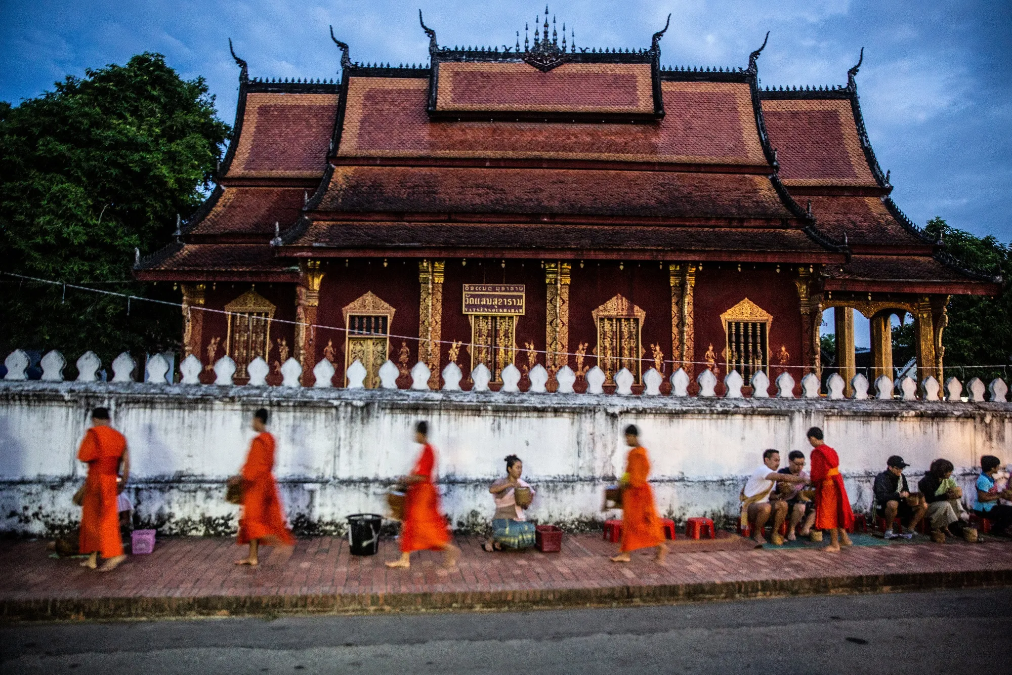 Monks collect alms from tourists and locals at a ceremony in Luang Prabang, Laos.