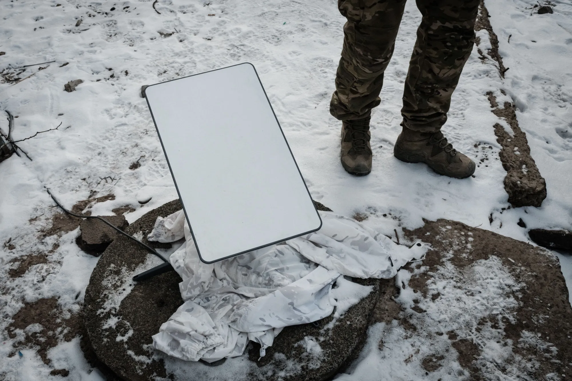A Ukrainian serviceman stands next to a Starlink antenna near Bakhmut.