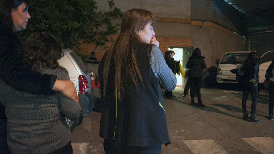 People remain outside a building during a strong quake in Chile.

