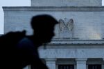 A bicyclist passes the Marriner S. Eccles Federal Reserve building in Washington, D.C.