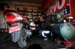 A mechanic fixes a scooter at her workshop in Sanothimi on the outskirts of Kathmandu on March 7.