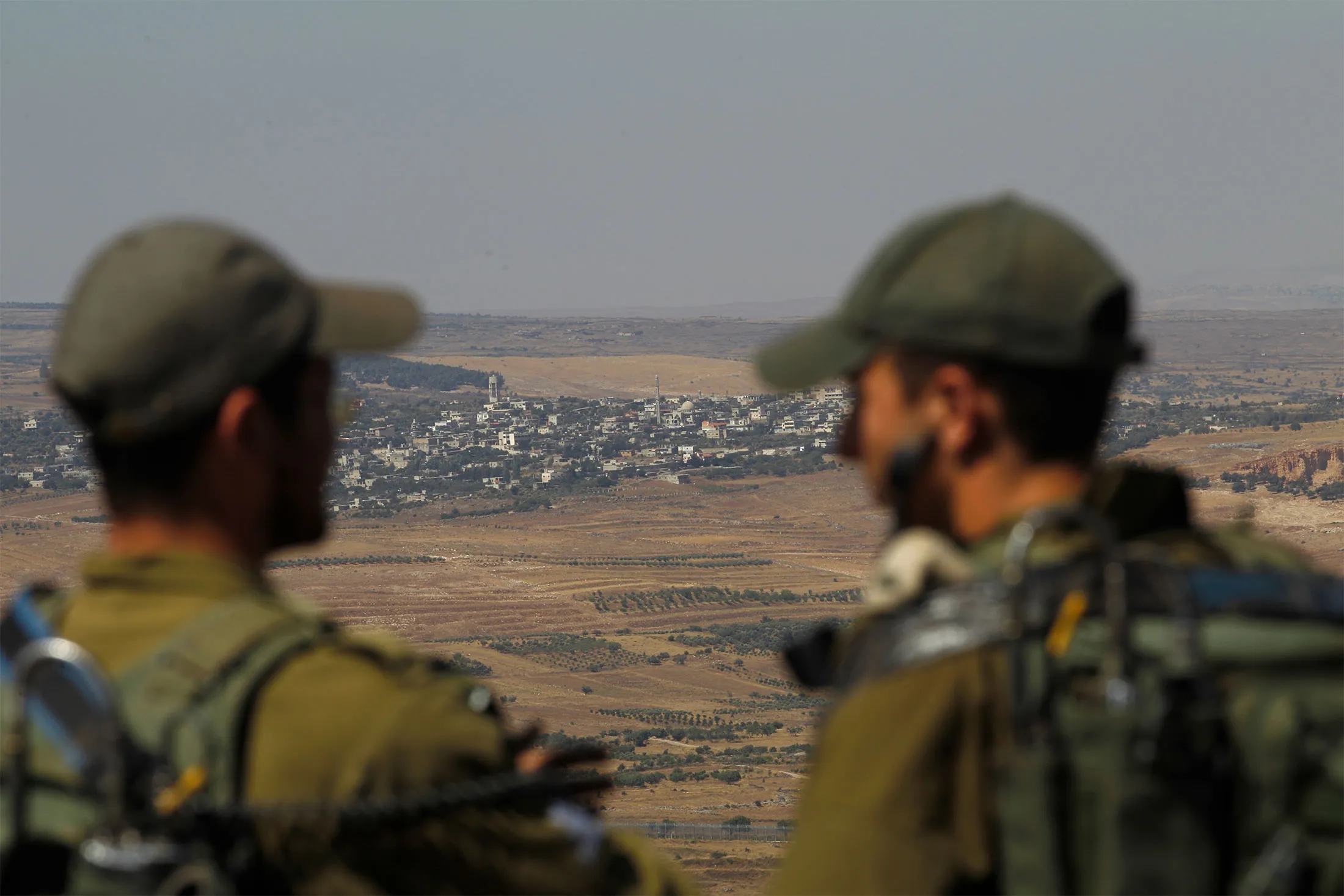 Israeli soldiers at an army base in the Israeli-annexed Syrian Golan Heights look out across the southwestern Syrian province of Quneitra.