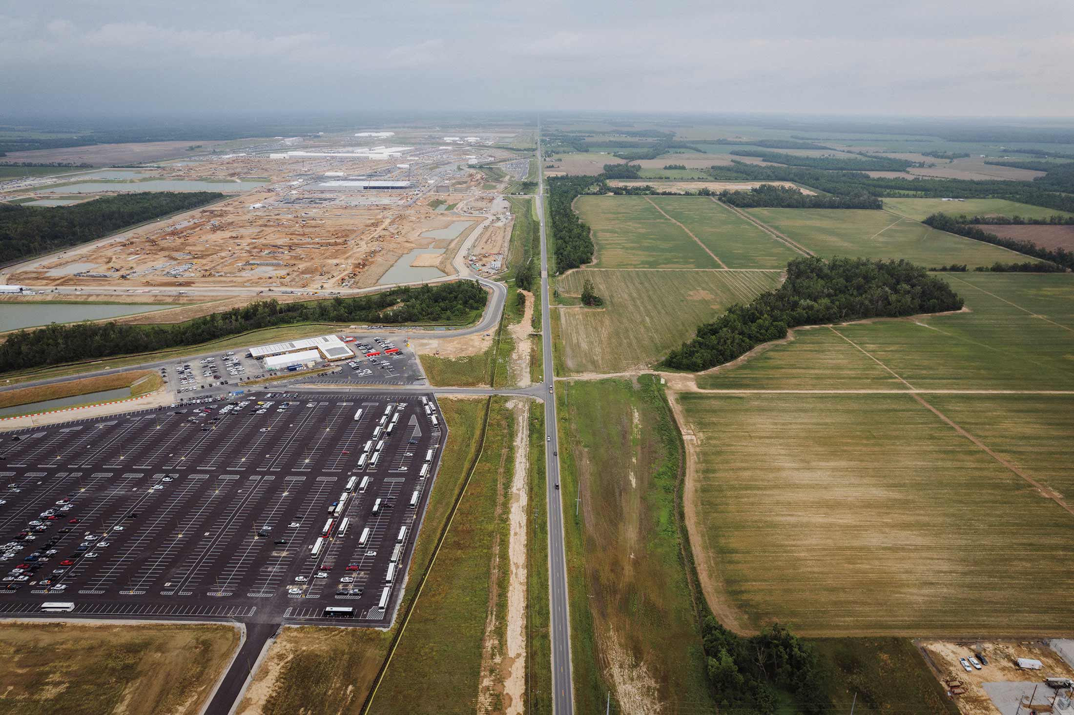 A photograph of the Meta data center on the left side and green farm land on the right with a road in the center in Richland Parish, Louisiana.