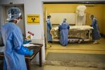 Forensic scientists arrange a body onto a full-body x-ray scanner at the Johannesburg Forensic Pathology Services mortuary in Johannesburg, South Africa, on Thursday, Oct. 18, 2018. 