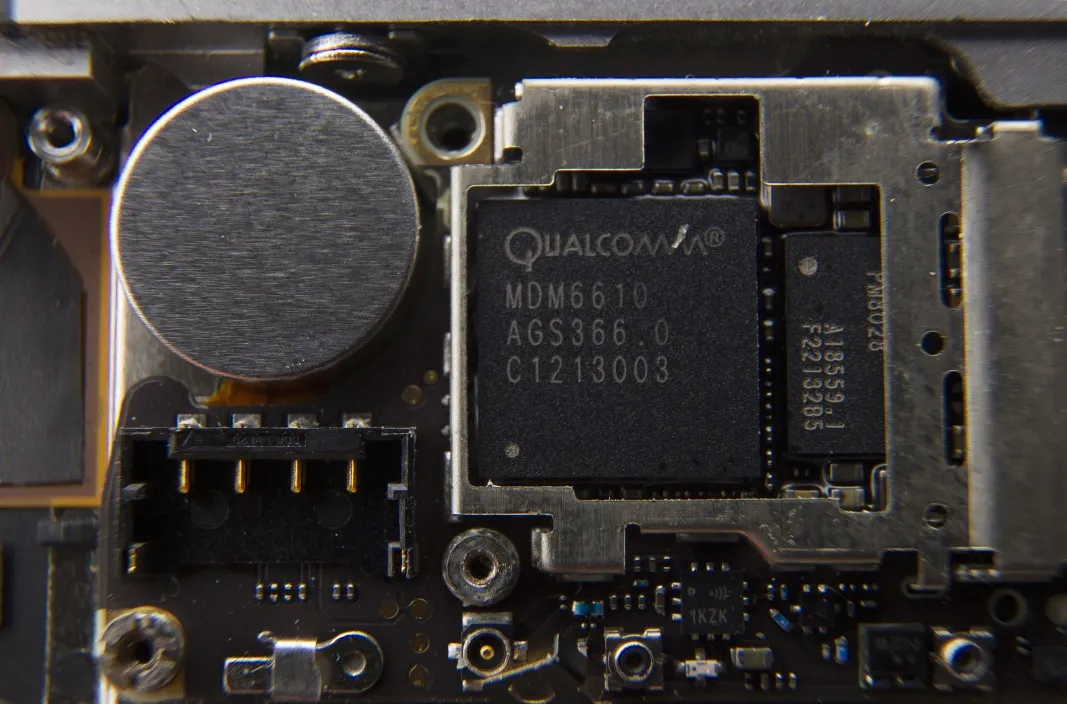 A Qualcomm Inc. baseband processor sits inside a smartphone sold as an Apple Inc. iPhone 4S in an arranged photograph in Hong Kong, China.