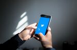 The Twitter Inc. logo is displayed on an Apple Inc. iPhone.