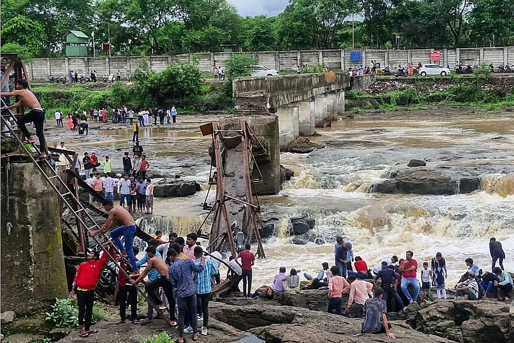 People gather near the site of a bridge collapse at Indrayani river near Kundamala village in Pune, on June 15.