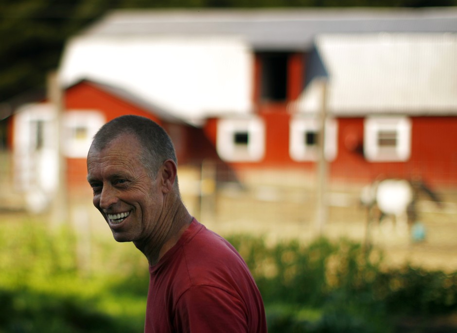 George McLellan smiles while weeding the vegetable garden at his farm in Unity, New Hampshire.