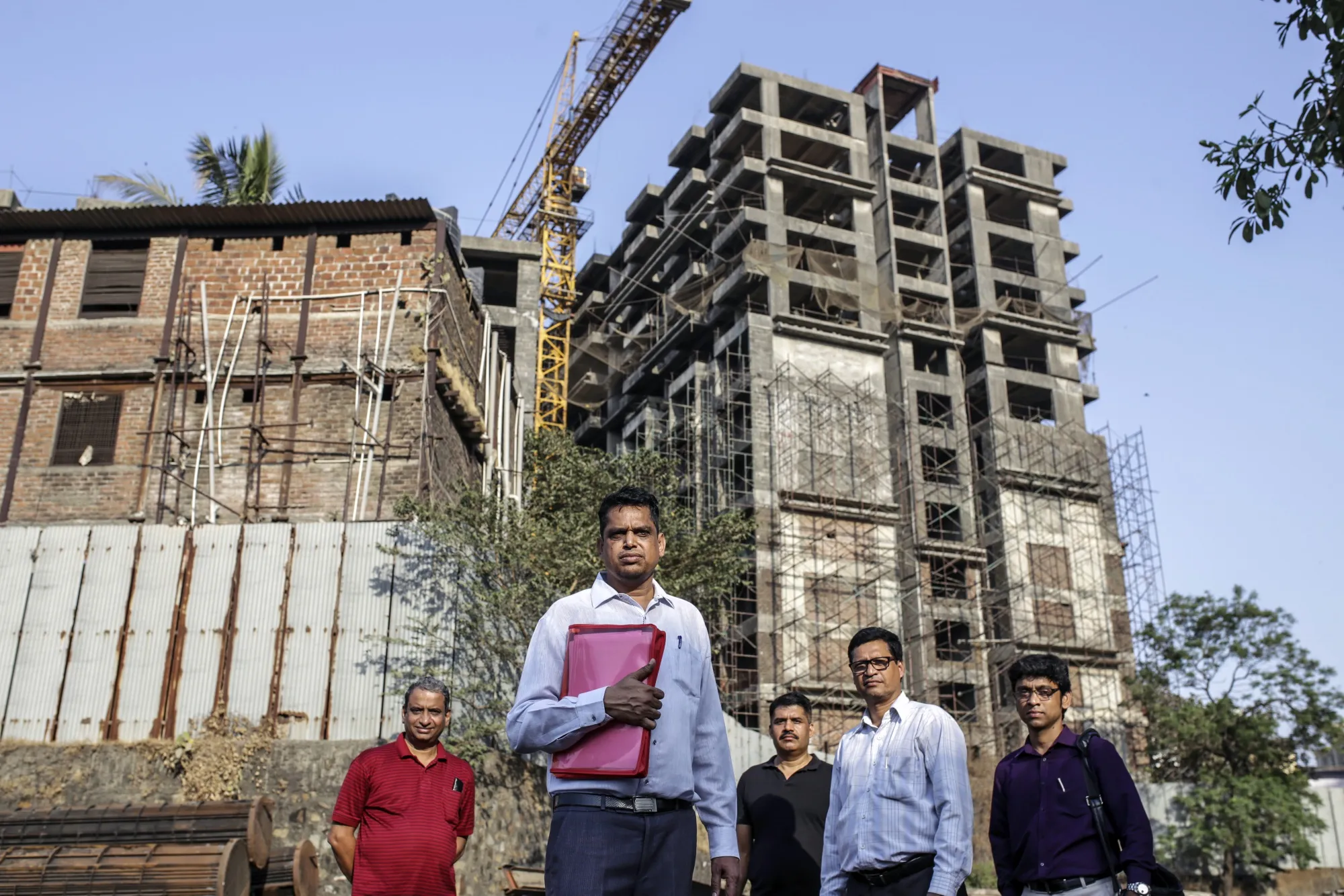 Sarju Saini, front, and other buyers at their unfinished Orbit apartment building.