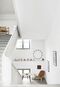The generous staircase, added in 1770, creates a cozy setting for a Shell Chair by Hans J. Wegner and a ledge displaying miniature chair replicas.