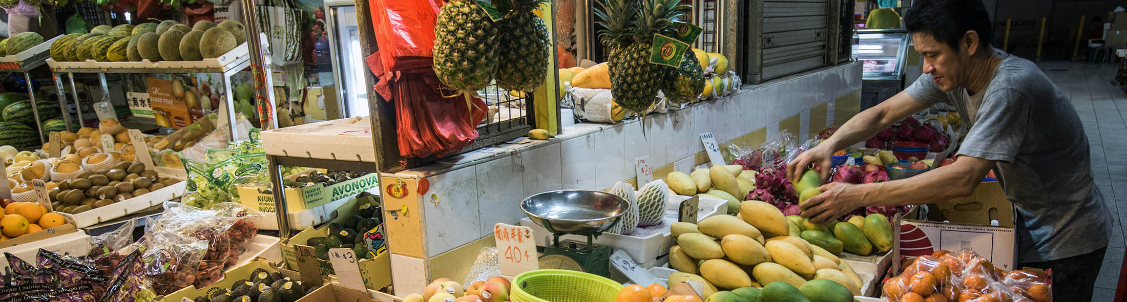 A vendor arranges fruit at a stall inside the Chinatown Wet Market in Singapore, on Wednesday, Nov. 4, 2015. The Monetary Authority of Singapore eased monetary policy for the second time this year last month, as trade ministry data showed the economy narrowly avoided a technical recession, saying weakening prospects for global growth will pose “headwinds” in the coming months.
