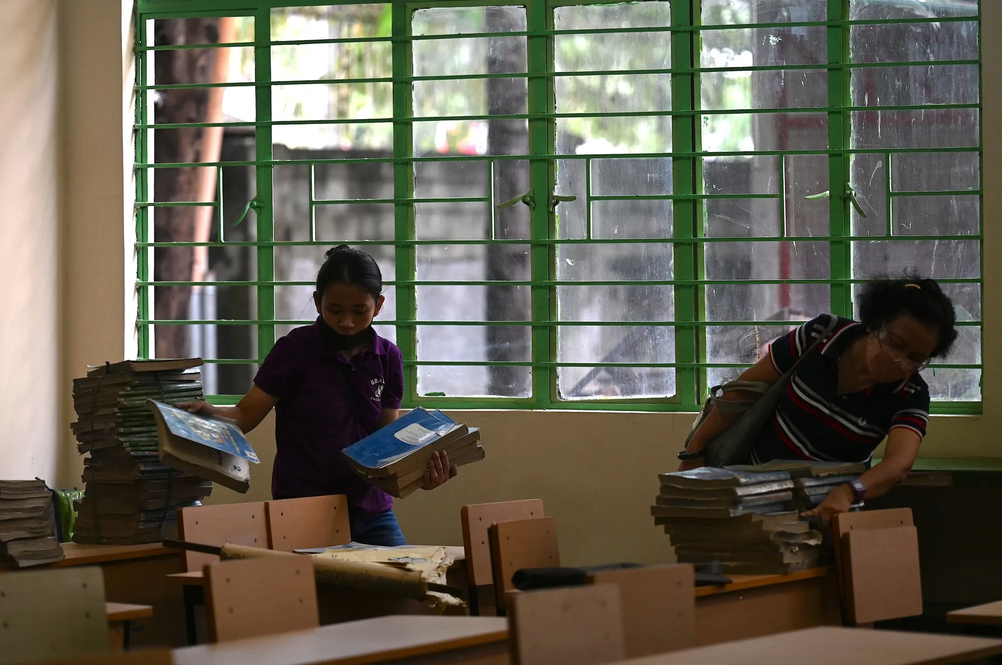 Volunteers arrange textbooks at an elementary school in Manila on August 5 ahead of reopening.