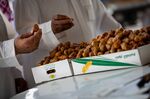 Traders and customers taste fresh dates at the local market in Buraidah, Saudi Arabia, on Sunday, Aug. 4, 2019. Saudi Arabia has been draining its reserves to cover social spending amid low oil prices.