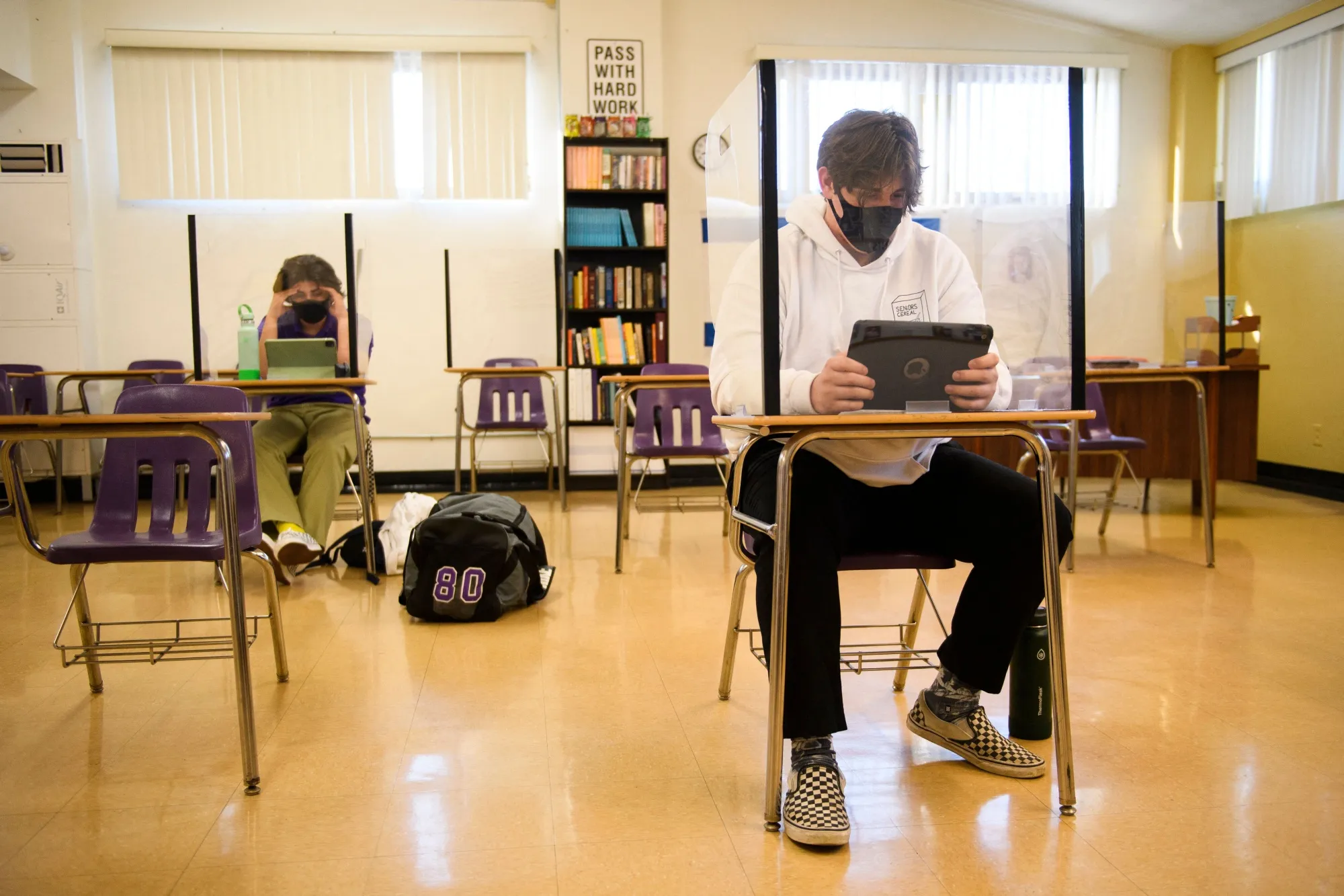Students sit&nbsp;behind barriers work on Apple iPad tablets as they return to in-person learning in Long Beach, California. Many school districts used their federal stimulus money to invest in mobile devices.&nbsp;